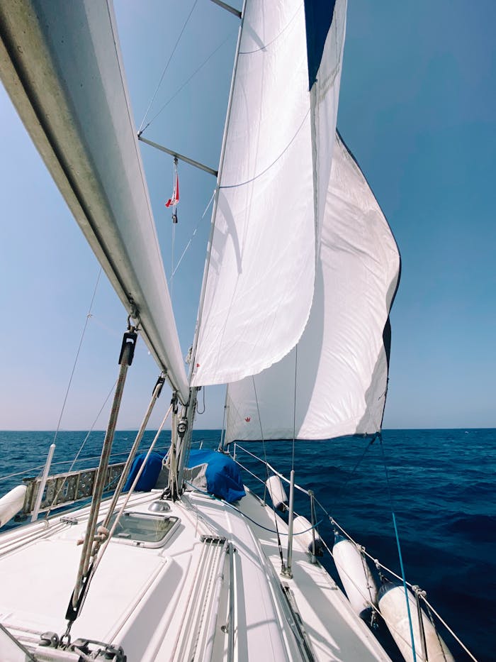 Sailboat with billowing white sails on the open sea, capturing the essence of freedom and adventure.